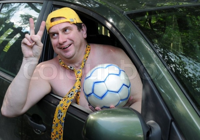 1530864-a-caucasian-man-wearing-a-yellow-baseball-cap-and-a-tie-without-a-shirt-is-hanging-out-of-the-car-window-showing-a-v-sign-and-holding-a-soccer-ball